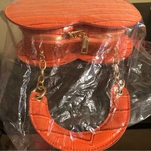 Orange croc embossed heart shaped purse with chain detail on handle